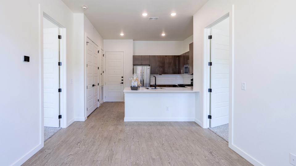 a clean white kitchen with hardwood floors and white cabinets at The  Campbell