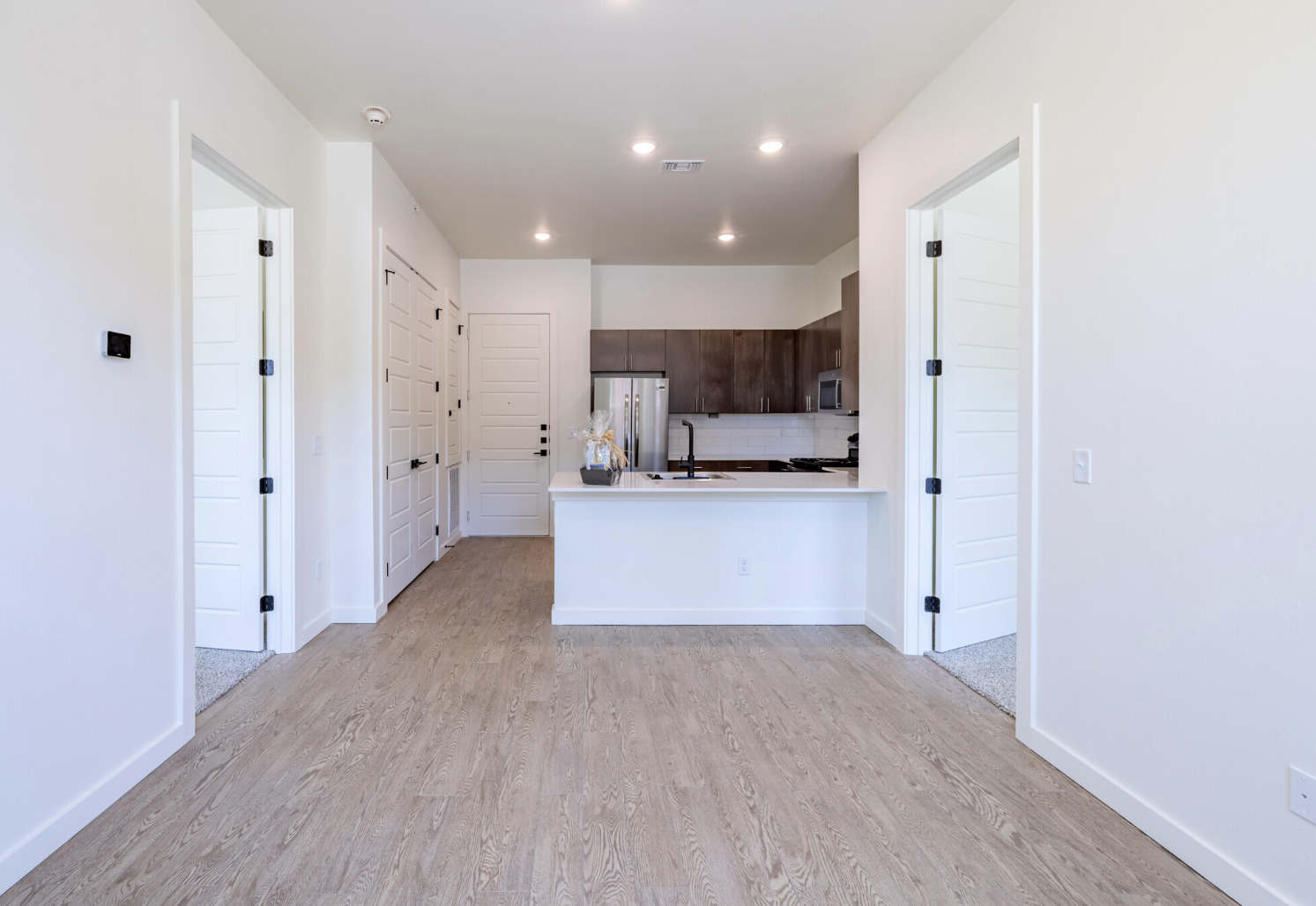 a clean white kitchen with hardwood floors and white cabinets at The  Campbell